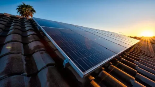 solar panels on roof with sun rising in the background