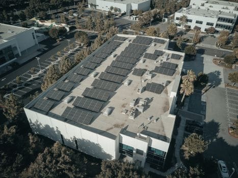 Rooftop with a bunch of solar panels on a large business warehouse.